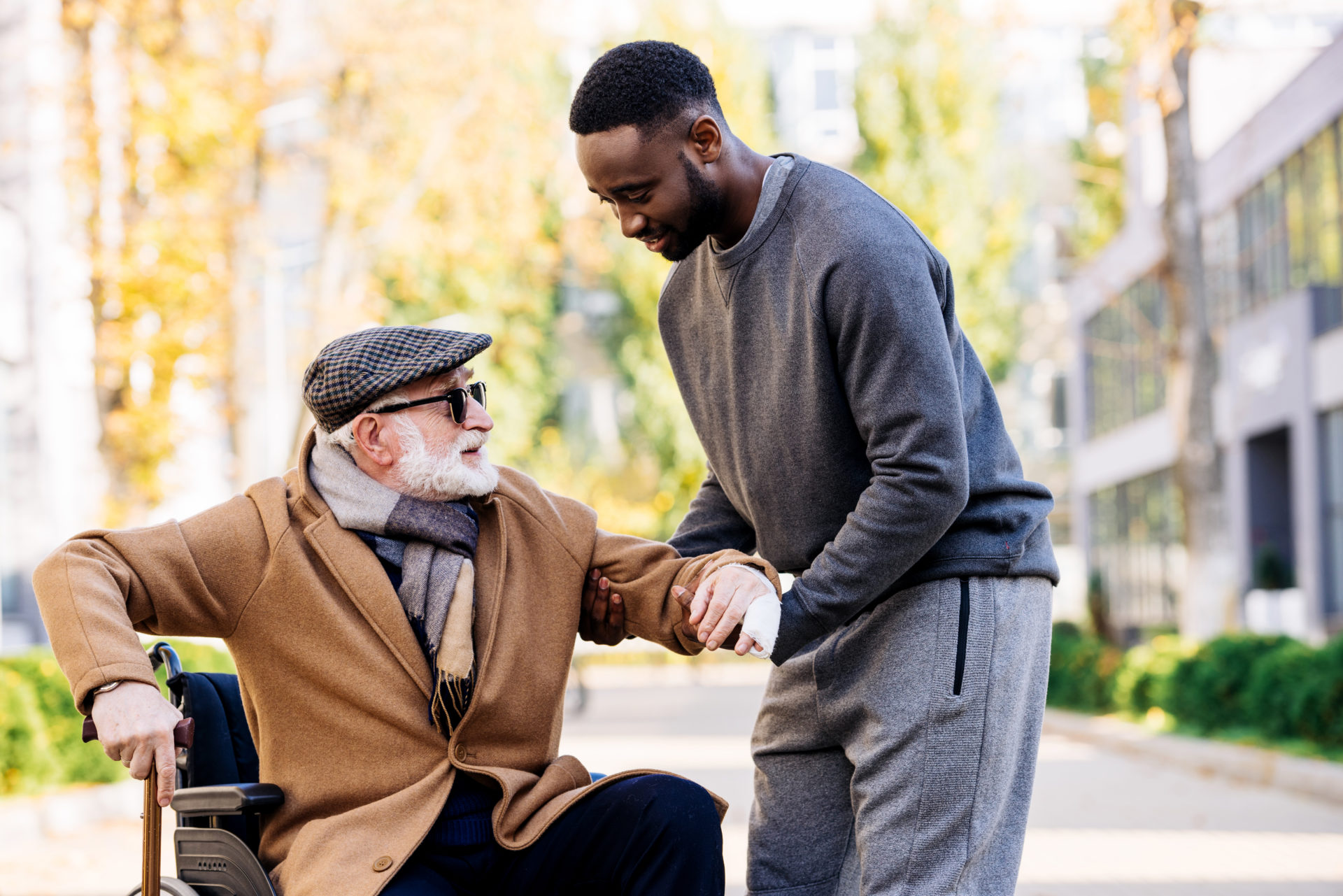 Caregiver helping elderly man out of wheelchair