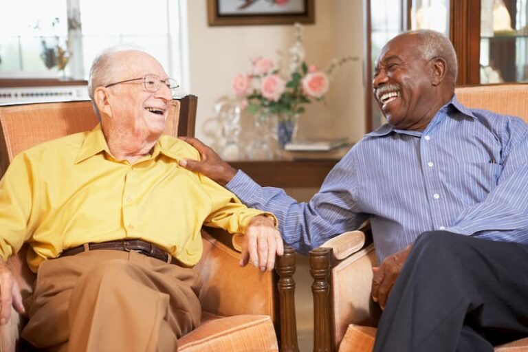 Two elder men visiting with each other sitting in chairs