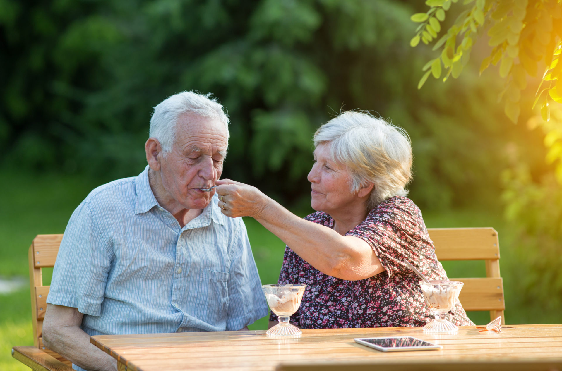 Old couple eating ice cream outside